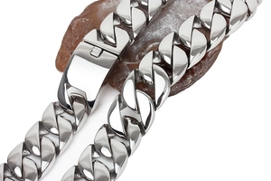 Macro shot of 31mm thick stainless steel Cuban link chain with polished box clasp on stone