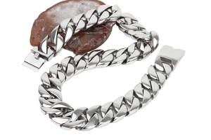 Detailed view of heavy silver-toned Cuban chain links resting on a natural stone base