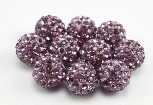 Macro view of purple pavé clay disco beads for jewelry making and handcrafting