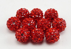 Macro shot of 10mm red disco ball clay beads with sparkling crystals for jewelry
