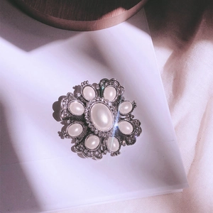 Baroque vintage pearl brooch with antique silver finish in an artistic floral sunburst style