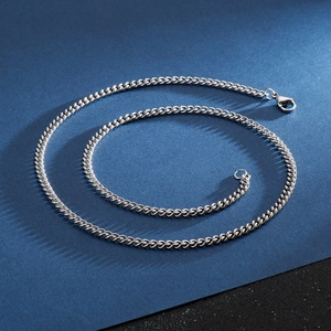 Polished silver stainless steel Cuban link chain necklace with lobster clasp on dark background