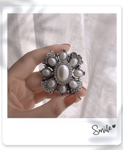 Close-up of Baroque vintage pearl brooch with silver metal finish and rhinestone accents