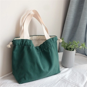 Detail of dark green canvas tote bag featuring thick fabric and drawstring closure