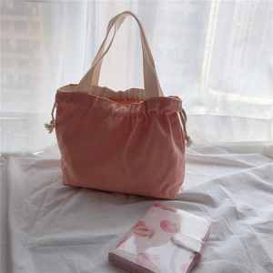 Detailed close-up of pink canvas tote bag featuring a drawstring closure and ribbon handle