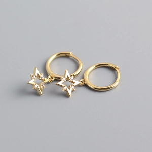 Close-up of golden S925 silver star earrings with sparkling pavé cubic zirconia
