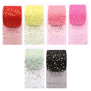 Close-up of sparkling gold star patterns on various colored tulle ribbon rolls