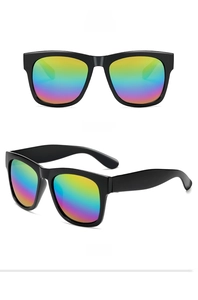 Detail view of oversized black matte sunglasses featuring vibrant rainbow tinted lenses