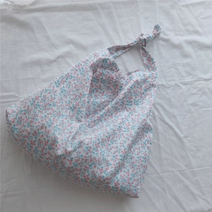 Close-up of floral cotton handbag with knotted handle and pink blue flower patterns