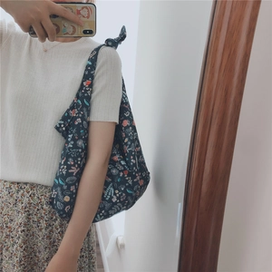 Black floral tote bag with knotted strap shown in a stylish mirror selfie outfit look