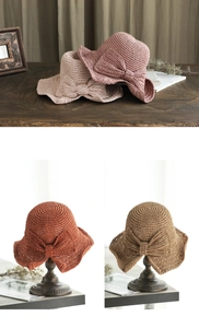 Gros plan de chapeaux de paille tissés avec détail nœud en plusieurs coloris naturels.