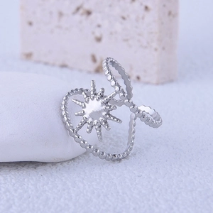 Minimalist stainless steel sun ring with beaded texture on a white textured stone surface