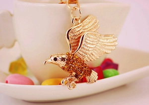 Nahaufnahme vom goldenen Adler Schlüsselanhänger mit Strass am Porzellanbecher