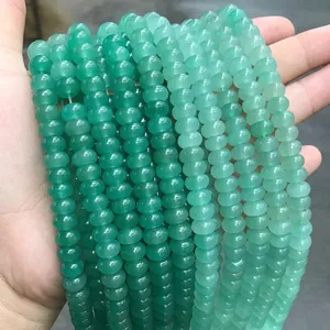Detail of multi-strand green natural stone abacus beads held by hand for DIY jewelry