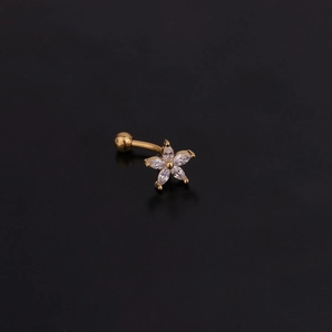 Macro view of golden stainless steel curved barbell featuring a zircon flower stud