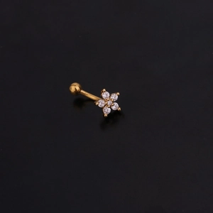 Macro shot of gold curved barbell with five-petal zircon flower on black background