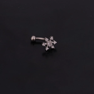 Macro view of snowflake zircon eyebrow ring with curved stainless steel bar on black background