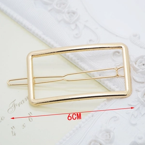 Close-up of 6cm golden minimalist rectangular hair clip on elegant relief background