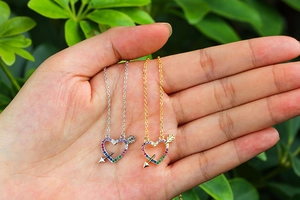 Close-up of heart arrow pendant with colorful cubic zirconia in gold and silver