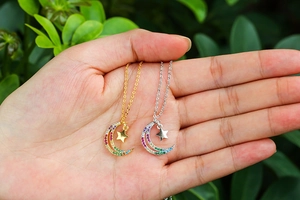 Close-up of star and moon necklaces with colorful crystals in gold and silver finish