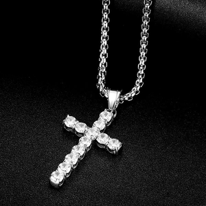 Vue macro d'un pendentif croix argenté avec zircone AAA sur une chaîne à maillons