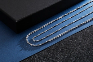 Artistic display of multiple silver stainless steel O-chains on a textured surface