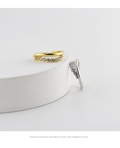 Detail of wavy S925 silver and gold rings featuring micro-pave cubic zirconia stones