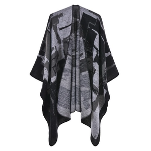 Detail of a knit shawl featuring black, white and grey geometric abstract patterns