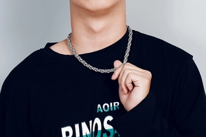Detail of silver stainless steel byzantine chain necklace worn on a black t-shirt