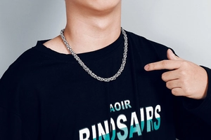 Detailed view of silver stainless steel woven keel chain necklace worn by male model