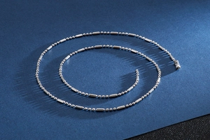 Gros plan d'un collier chaîne en argent poli montrant la texture du métal brillant