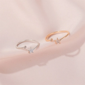 Elegant star-shaped open ring set in silver and rose gold over a pink silk background