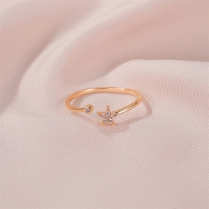 Macro view of rose gold star ring with pave diamonds on soft pink silk fabric background