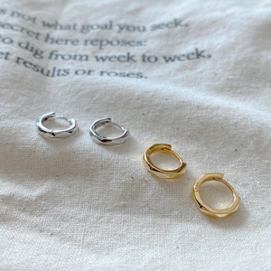Macro shot of silver and gold geometric faceted S925 sterling silver hoop earrings
