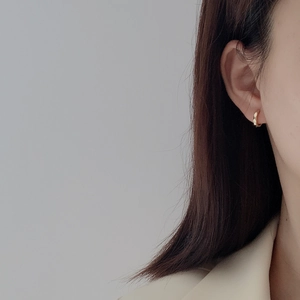 Minimalist 925 sterling silver gold-plated faceted hoop earrings on a female model
