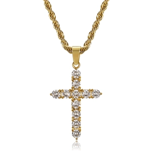 Macro shot of gold-plated hip hop cross pendant with round zircon inlay on twist chain