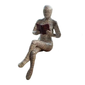 Close-up of reading woman figurine with unique newspaper print texture on resin