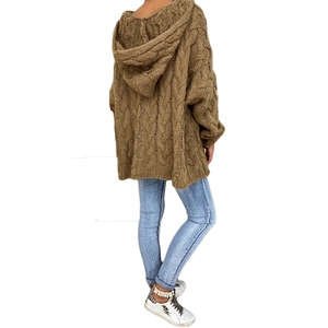 Rear view of brown chunky cable-knit hoodie showing oversized fit and texture