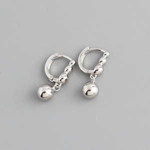 Detailed view of silver hoop earrings with a polished metallic bead charm