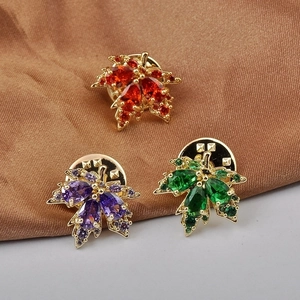 Three maple leaf brooches with sparkling zircon stones in red, purple and green colors