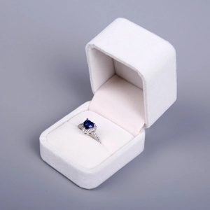 Detail view of a heart-shaped sapphire ring inside a premium white velvet jewelry box