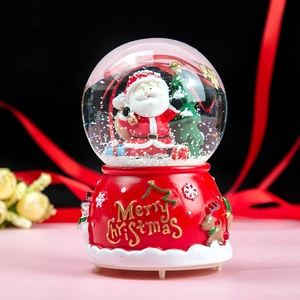 Close-up of a Christmas crystal ball with Santa, snowflakes, and Merry Christmas text