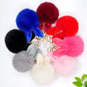 Top view of colorful rabbit ear pompom keychains in plush material with gold metal rings