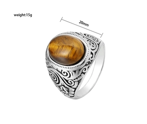 Close-up of vintage silver ring with oval tiger eye stone and intricate engraved patterns