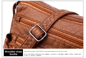 Detail of adjustable silver buckle on brown lychee texture leather shoulder bag strap
