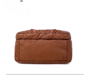Detailed bottom view of brown soft faux leather bag showing reinforced stitching and texture