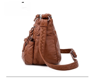 Detail view of brown soft leather crossbody bag showing side layers and texture