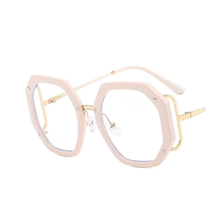 Moderne rosa polygonale Brille mit goldenen Metallbügeln und Nietendetails auf weiß