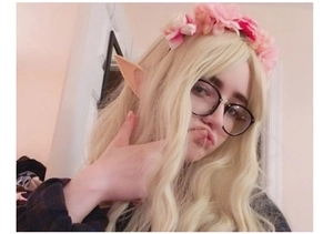 Cosplay elf ears and pink flower headband accessory shown on a blonde character model