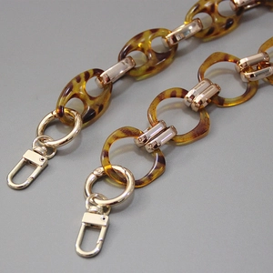 Detail of tortoise shell resin links with gold metal clasp and rotating lobster hooks